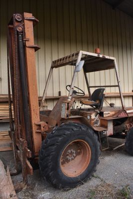 un chariot élévateur à fourche garé devant un bâtiment