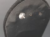 a close up of a black hat with a button on it