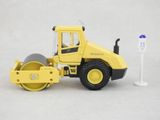 a yellow toy road roller and a white sign