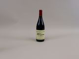 une bouteille de vin rouge posée sur une table blanche