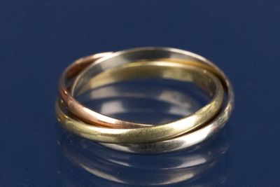 un gros plan d'une bague en or et en argent sur un fond bleu