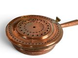 a small copper pot with a wooden handle on a white surface