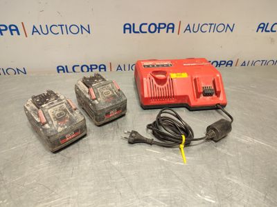 quelques piles posées sur une table, à côté d'un chargeur