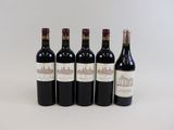 quatre bouteilles de vin sont alignées sur une surface blanche