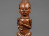 a wooden statue of a man with a hat on his head