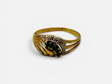 a close up of a gold ring with a black stone