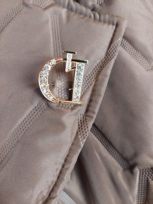 a gold brooch with a letter d on it