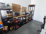 une pièce avec un bureau, des étagères et un ordinateur posé dessus