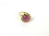 gros plan d'une bague en pierre rose sur une surface blanche
