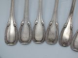 six silver spoons are lined up in a row on a table