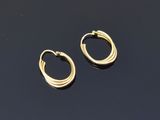 a pair of gold hoop earrings on a black surface