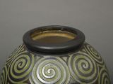 a vase with a green and black design on it