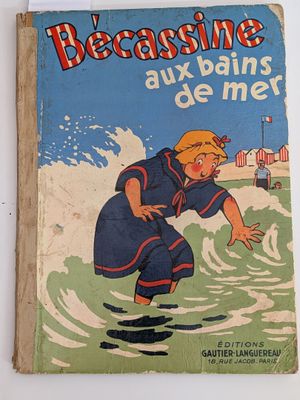 un vieux livre pour enfants avec l'image d'un garçon sur une planche de surf dans l'eau