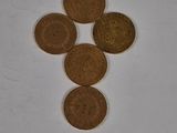 four coins are arranged in a triangle on a white surface