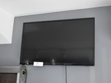une télévision à écran plat fixée au mur au-dessus d'une cheminée