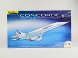 maquette d'un avion de ligne Concord dans une boîte posée sur une surface blanche