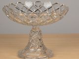 a glass bowl on a wooden table with a gray wall in the background