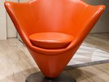 an orange chair that is sitting in a room