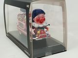 a box with a toy clown inside of it on a white surface