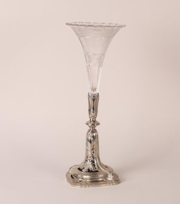 un vase ancien en verre plaqué argent, posé sur un socle, sur fond blanc