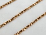 a close up of a gold chain on a white surface