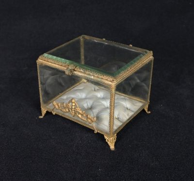 a small glass box with a marble inside on a black surface