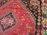 a red rug with a black border on the floor