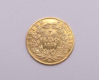 gros plan d'une pièce d'or sur une surface blanche