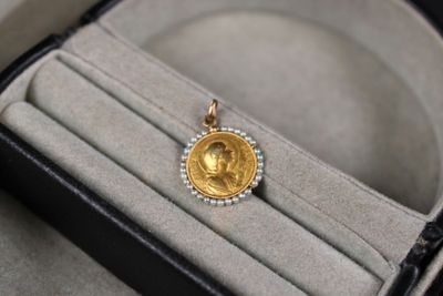 une pièce d'or posée dans une bague, dans une boîte