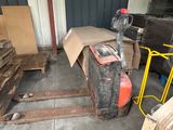 Plusieurs palettes de bois sont entreposées dans une zone de stockage, à côté d'autres palettes de bois.