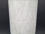 a white vase sitting on a pedestal on a black background