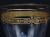 a glass with a gold decoration on it on a table