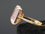a gold ring with a pink stone in the middle of it