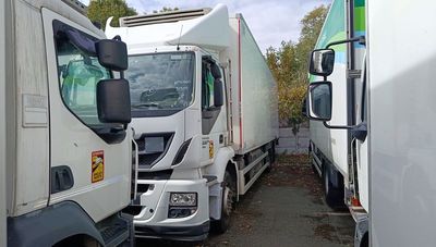 two white trucks parked next to each other on the side of the road