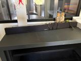 une table noire sur laquelle se trouve un bocal en verre, devant une fenêtre