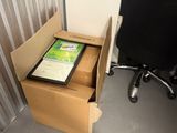 a box with a computer inside of it next to a chair