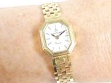 a gold wrist watch on a woman ' s wrist