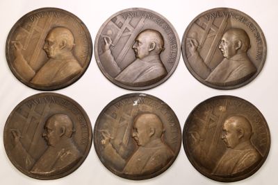 six bronze medallions of men with different faces on them