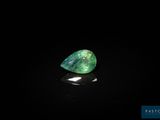 a green tourmaline stone on a black surface