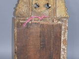 an old wooden clock with a pink ribbon on it