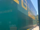 a green semi truck with a yellow stripe on the side of it