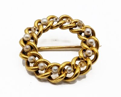 une image représentant une broche en or ornée de perles sur fond blanc