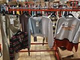 de nombreuses chemises suspendues à un portant dans un magasin