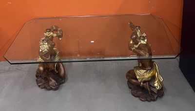 une table en verre sur laquelle sont posées deux figurines