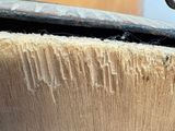 a close up of a piece of wood with a hammer sticking out of it