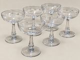 six verres à vin vides posés sur une surface blanche