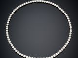 a pearl and diamond necklace on a black background