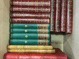 Plusieurs livres sont empilés dans une boîte en carton posée sur une table