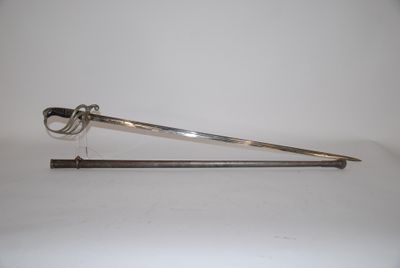 une cuillère en argent et une paire de ciseaux posés sur une surface blanche