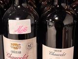several bottles of red wine are lined up on a shelf
